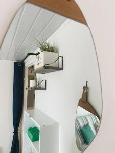 un espejo colgado en una pared en una habitación en Chez Zivou au pied de la plage, en Mers-les-Bains