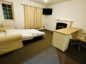 Habitación con 2 camas, escritorio y chimenea. en Stunning 5-Bed House in Peterborough host 15 g en Peterborough