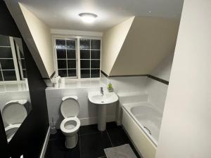 a bathroom with a toilet and a sink and a tub at Stunning 5-Bed House in Peterborough host 15 g in Peterborough