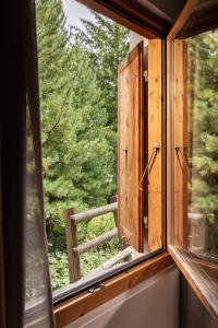 a window with a view of a forest at Hotel Chesa Rosatsch - Home of Food in Celerina