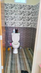 een badkamer met een toilet en een muur bij Homestay Dena Moon Inn in Tumpat