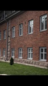 - un bâtiment en briques rouges avec des fenêtres blanches dans l'établissement Kaunis huoneisto Turun Kakolassa, à Turku
