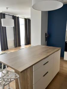 eine Küche mit einem Holztisch und Stühlen in der Unterkunft Vigne et mer-Spacieux Appartement Haussmannien-2chambres-Wifi in Béziers