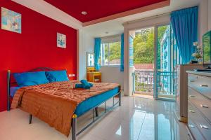 czerwona sypialnia z łóżkiem z niebieskim pluszowym zwierzakiem w obiekcie Nice to meat you Rooms w Patong Beach