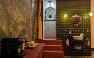 ein Bad mit einer Treppe, einem Waschbecken und einem Spiegel in der Unterkunft LA GALANTE in Faugères