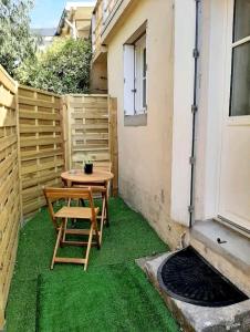 un pequeño patio con una mesa y césped verde en Logement indépendant avec extérieur privatif et clôturé, en Batz-sur-Mer