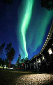 een afbeelding van het noorderlicht in de lucht boven een huis bij Pyhä Igloos in Pyhätunturi