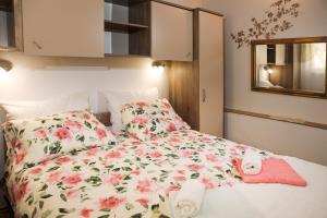 a bed with a flowered blanket and pillows on it at Apartments Faris in Kanfanar