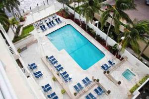 an overhead view of a swimming pool with blue lounge chairs at Beach Apartments by Avi Real Estate in Fort Lauderdale