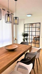 a dining room with a wooden table and chairs at AMAO-Curry - City Center - 100 m2 - 7 Personen - Balkon - 2 Schlafzimmer - KingSize Betten in Lahr