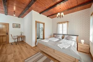 a bedroom with a large bed with a wooden ceiling at Vila IVAN in Velika Gorica