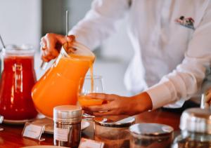 a person is making a drink in a glass at Hotel Chalé Capitólio in Capitólio