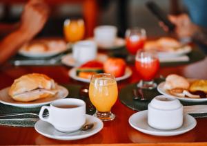a table with plates of food and a cup of coffee at Hotel Chalé Capitólio in Capitólio