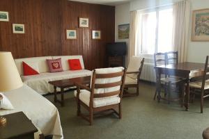 una camera d'albergo con letto, tavolo e sedie di Sunny 2 BR w large terrace, stunning views & pool a Crans-Montana