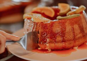 a piece of cake on a plate with a fork at Hotel Chalé Capitólio in Capitólio