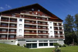 a large building with balconies on the side of it at Sunny 2 BR w large terrace, stunning views & pool in Crans-Montana