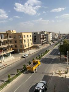 uma vista superior de uma rua com carros e um camião amarelo em Zirka Apartments Duhok em Dohuk
