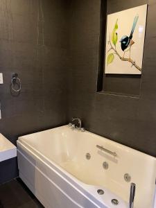 a white bath tub in a bathroom with a bird picture at Villa near the Beach with 5bedroom VIP in Vung Tau