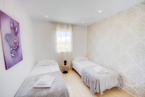 Una habitación blanca con dos camas y una ventana. en Sunset Dream Penthouse, en San Miguel de Abona 32 fotos más