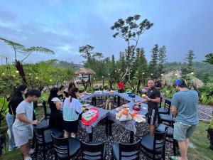 un grupo de personas de pie alrededor de una mesa en PuBin Paradise, en Hòa Bình