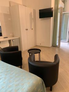 una camera con un letto e due sedie e un tavolo di I Monolocali Del Boccaccio a Milano Marittima