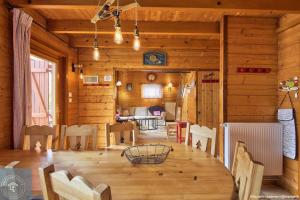 a dining room with a table in a wooden house at Chalet Les Brimbelles avec Jacuzzi in Gérardmer