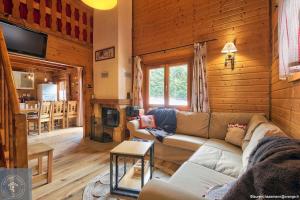 a living room with a couch and a fireplace at Chalet Les Brimbelles avec Jacuzzi in Gérardmer