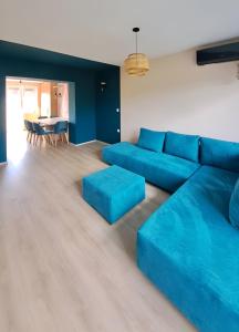 ein Wohnzimmer mit einem blauen Sofa und einem Tisch in der Unterkunft Elegant 1BR Dream Apartment in Central Ohrid in Ohrid