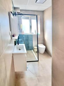 ein Bad mit einem Waschbecken und einem WC in der Unterkunft Elegant 1BR Dream Apartment in Central Ohrid in Ohrid