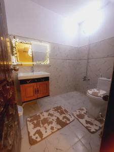 a bathroom with a toilet and a sink and a mirror at Charming Home banglow in Karachi