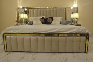 a large bed with a metal frame and pillows at Charming Home banglow in Karachi