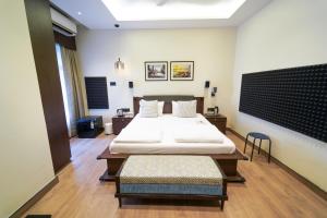 um quarto com uma cama grande e uma mesa em Central Bed & Breakfast em Calcutá