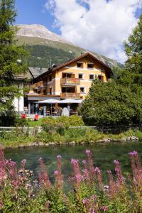 een gebouw naast een rivier met een berg bij Hotel Chesa Rosatsch - Home of Food in Celerina