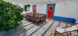 a patio with a table and chairs and a red door at Casa Alentejana com piscina e grande jardim 