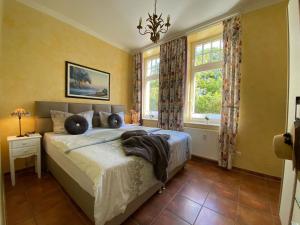 ein Schlafzimmer mit einem großen Bett und zwei Fenstern in der Unterkunft Palais am Park - App. Luxembourg - Ostseebad Kühlungsborn-Ost in Kühlungsborn