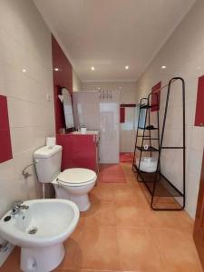 Un baño con un inodoro blanco y un lavabo. en Casa Amarela - Praias Alqueva, en Póvoa de São Miguel