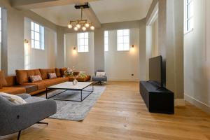 uma sala de estar com um sofá e uma televisão em 12A, Luxe & Uniek - Bioscoopzaal - Terras - Uitzicht em Oisterwijk
