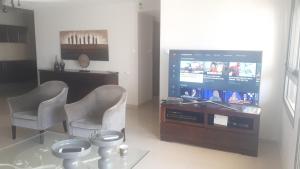 een woonkamer met een flatscreen-tv en 2 stoelen bij Haatsmaout City center apartment Ashdod in Ashdod