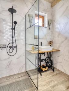 uma casa de banho com um chuveiro e um lavatório. em Nyírfa-Lak Apartman em Szilvásvárad