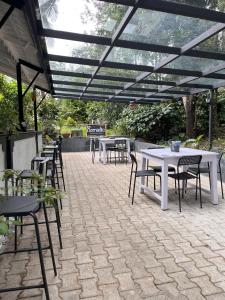 a patio with tables and chairs under a pergola at beNomadic Eco Hostel, Madikeri, Coorg in Suntikoppa