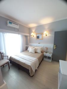 um quarto com uma cama grande e uma janela em Hotel Valles em Mar del Plata