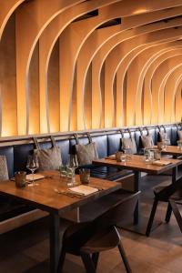 una fila di tavoli in un ristorante con bicchieri da vino di Hotel Chesa Rosatsch - Home of Food a Celerina