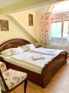 um quarto com uma cama grande e uma janela em Talizmán Étterem Panzió em Miskolc