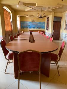 Penuel Plaza Hotel في Kimana: قاعة اجتماعات كبيرة مع طاولة وكراسي كبيرة