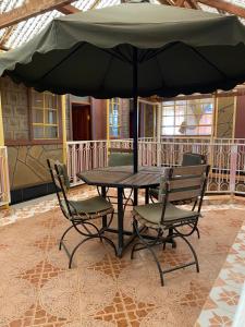 a table and chairs with an umbrella on a patio at Penuel Plaza Hotel in Kimana