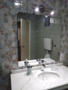 uma casa de banho com um lavatório e um espelho grande em FloSer em Rivera