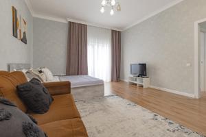 アスタナにあるАпартаменты в ЖК Apple Cityのソファとテレビのあるリビングルーム