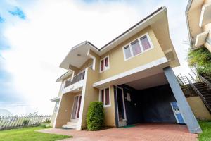 a house with a garage in front of it at Fortune Retreats in Ooty