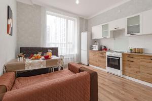 a kitchen and living room with a couch and a table at Апартаменты в ЖК Apple City in Astana