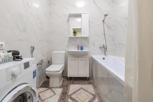 アスタナにあるАпартаменты в ЖК Apple Cityのトイレ、洗面台、洗濯機を備えた白いバスルーム +16枚の写真